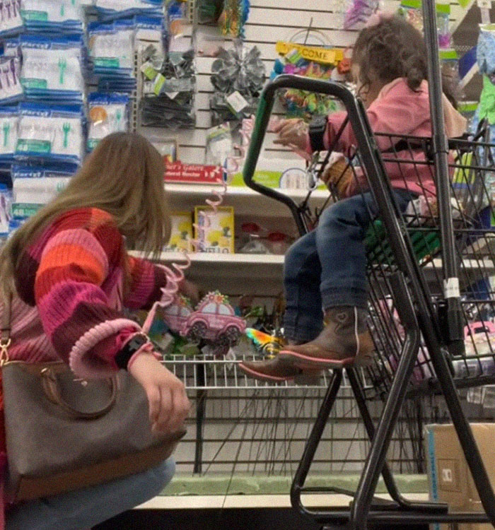 Mom and daughter wearing child leash at the grocery store.