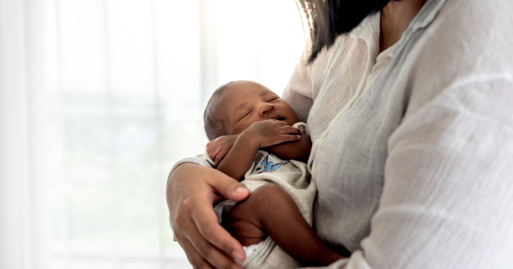 12-day-old baby newborn son, sleeping with his mother being held