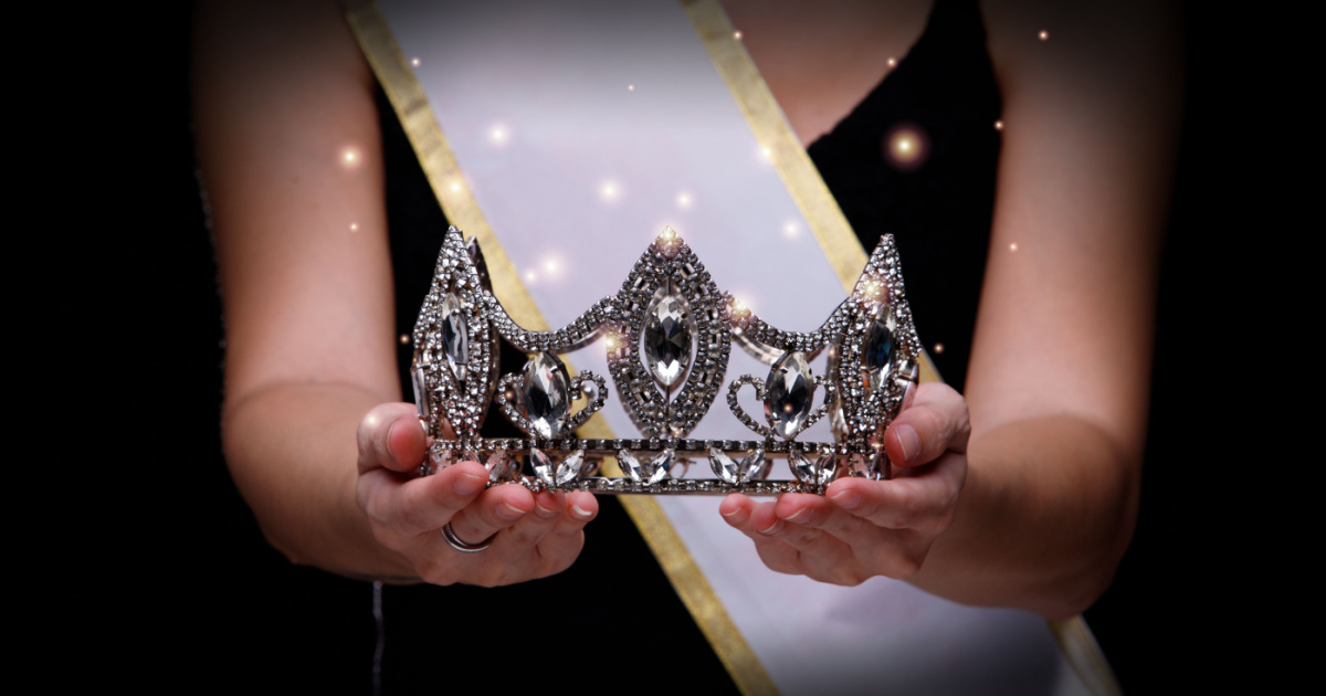 Prize Winning Award for Winner of Miss Beauty Queen Pageant Contest is Sash, Diamond Crown, studio lighting abstract dark draping textile background