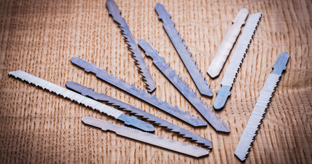 composition of blades for electric jigsaw on vintage wooden board

