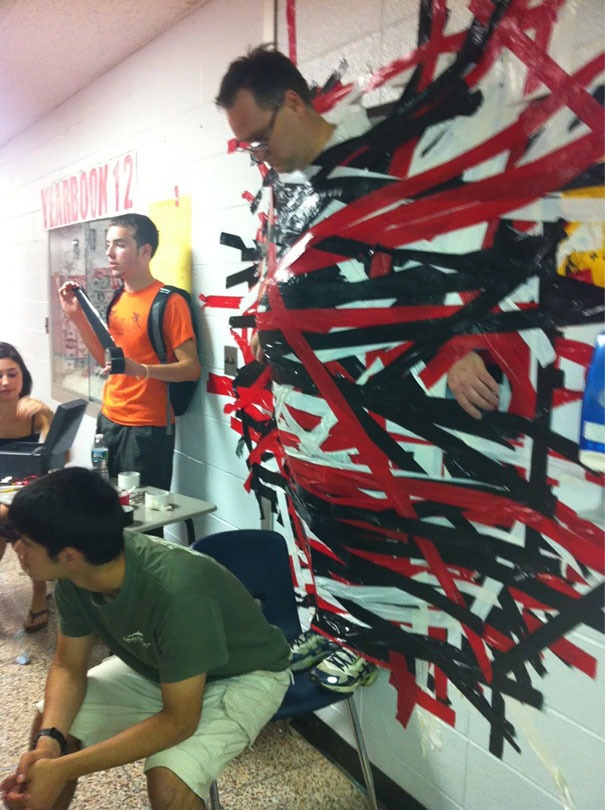 Principal doing a fundraiser by taping himself to the wall