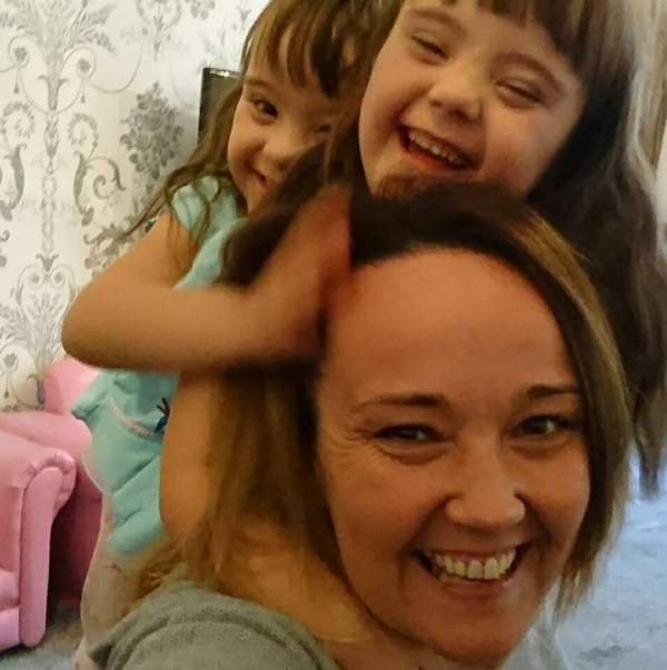 Twins with Down syndrome hugging their mom
