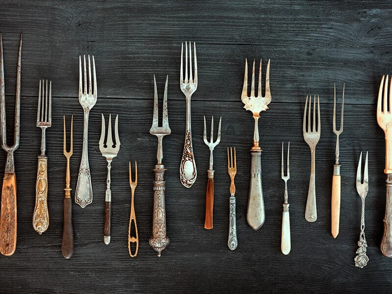 A variety of forks used for different foods in fine dining establishments