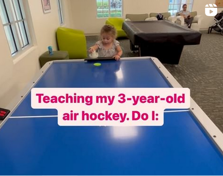 Little girl at air hockey table