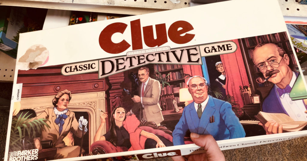 New Hope, Minnesota - May 26, 2019: Hand holds a classic, vintage Clue Detective board game, from the 1990s. Made by Parker Brothers
