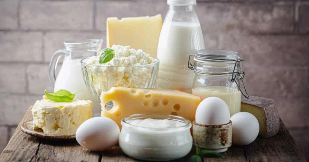 Fresh dairy products, milk, cottage cheese, eggs, yogurt, sour cream and butter on wooden table
