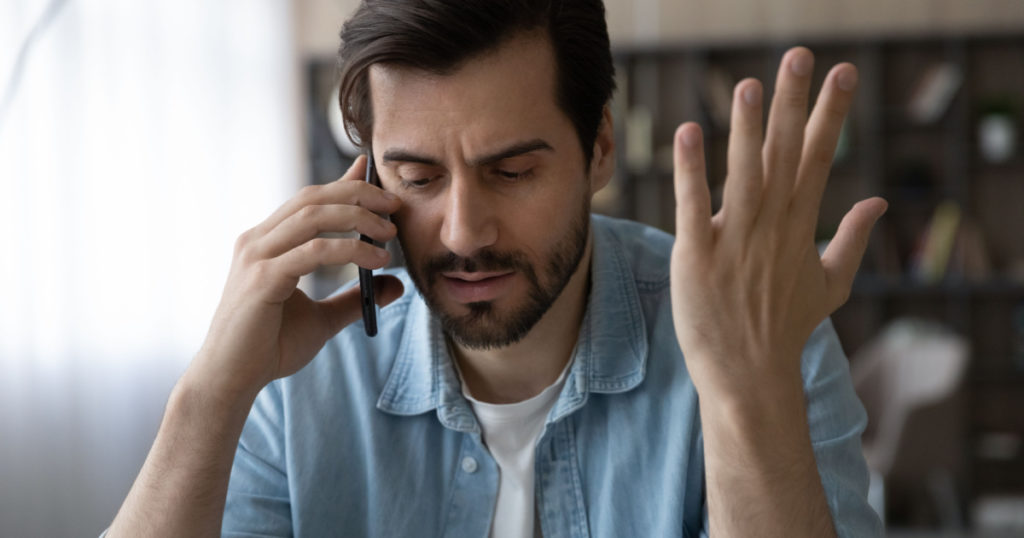 Professional misfortune. Troubled casual businessman call boss partner discuss business failure ask for advice in difficult situation. Unhappy young male share personal problems with friend by phone

