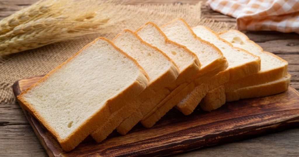 Sliced white bread on wooden board
