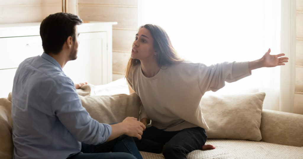 Misunderstanding. Angry worried young spouses quarreling arguing at home, annoyed nervous millennial wife shouting screaming on frustrated husband accusing in cheat threatening with breakup divorce
