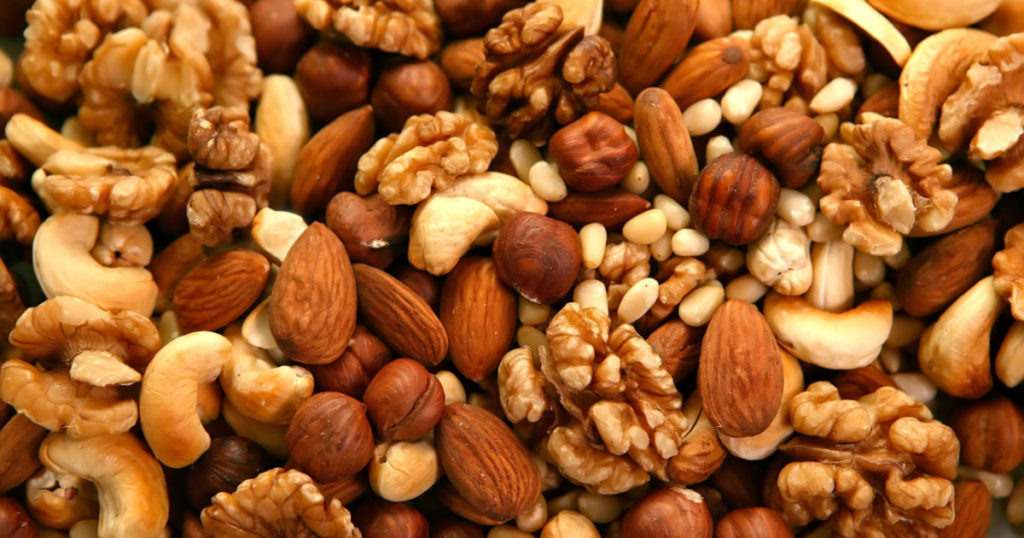 Peeled nuts in bulk as background: walnut, almonds, cashews
