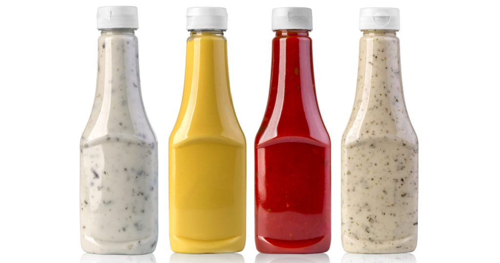 barbecue sauces in glass bottles on white background
