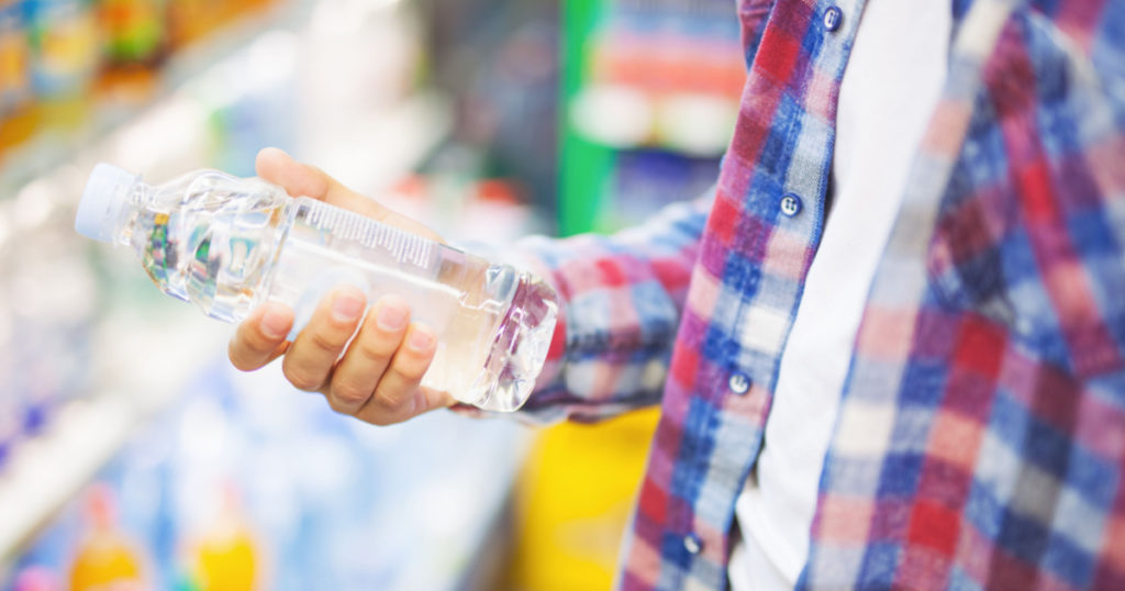 Man holding a bottle of water in grocery store

