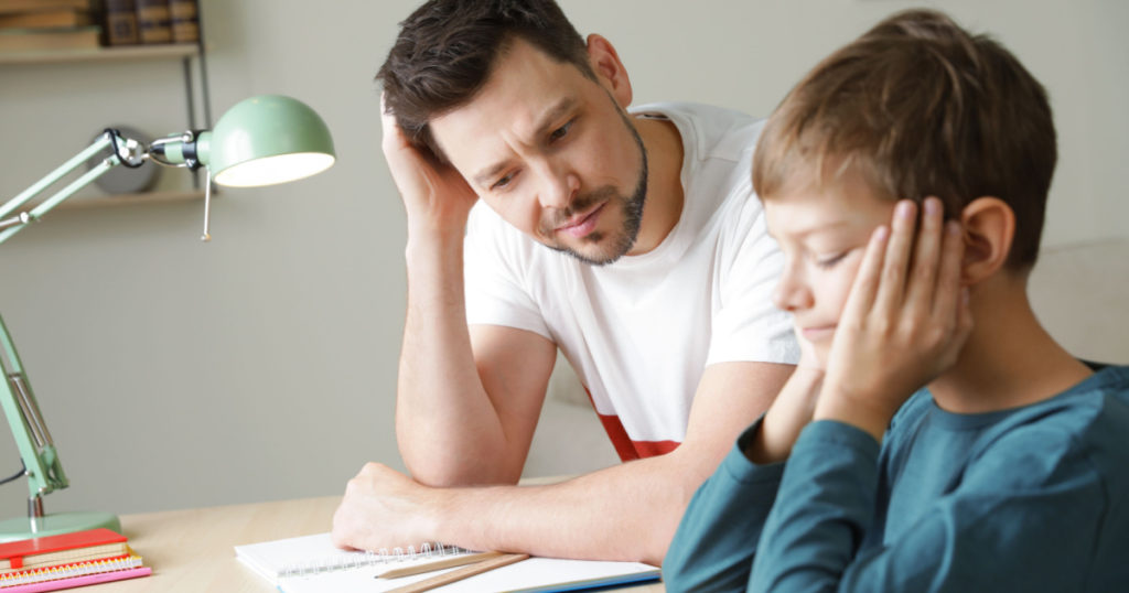 Dad struggling to help his son with school assignment at home
