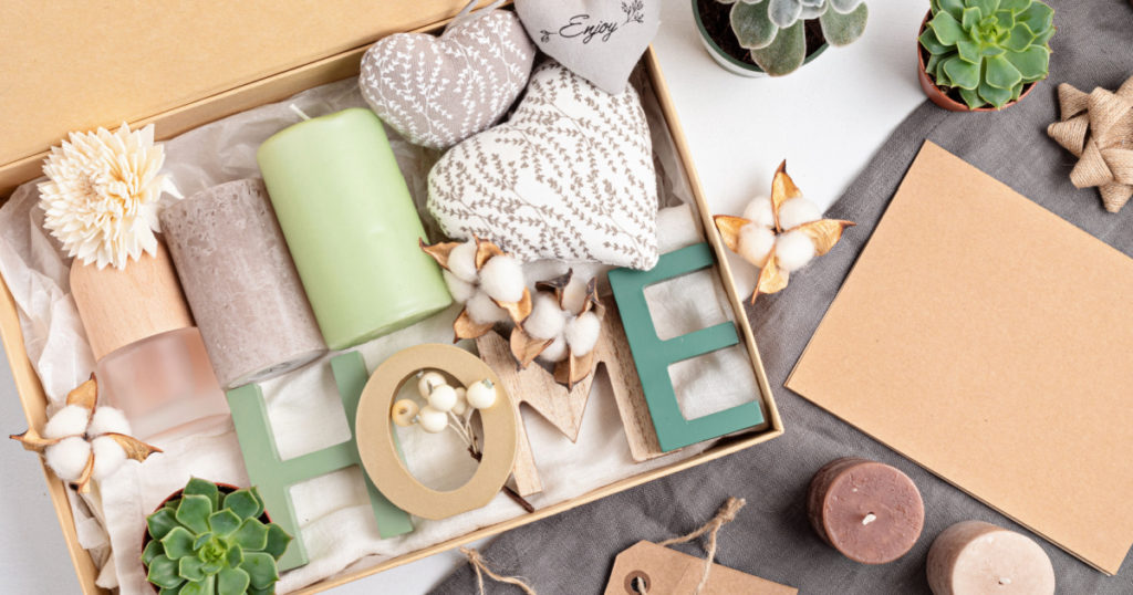 Preparing care package, seasonal gift box with candles, succulent, interior scent. Personalized eco friendly basket for family and friends for thankgiving, christmas, mothers day holidays.