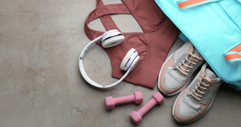 Flat lay composition with gym bag and sportswear on grey table