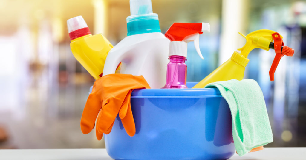 Basket with cleaning items on blurry background
