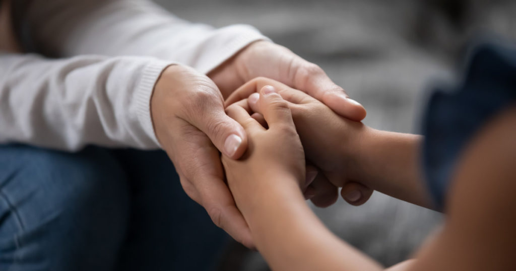parent holding childs hands