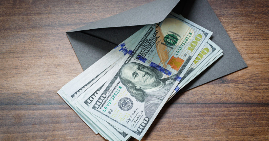 American dollars and envelope on table closeup
