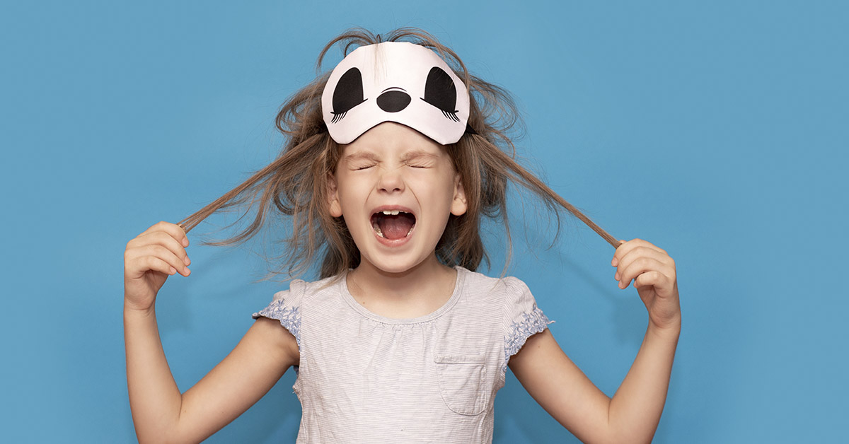 young girl yelling, pulling hair. blue background