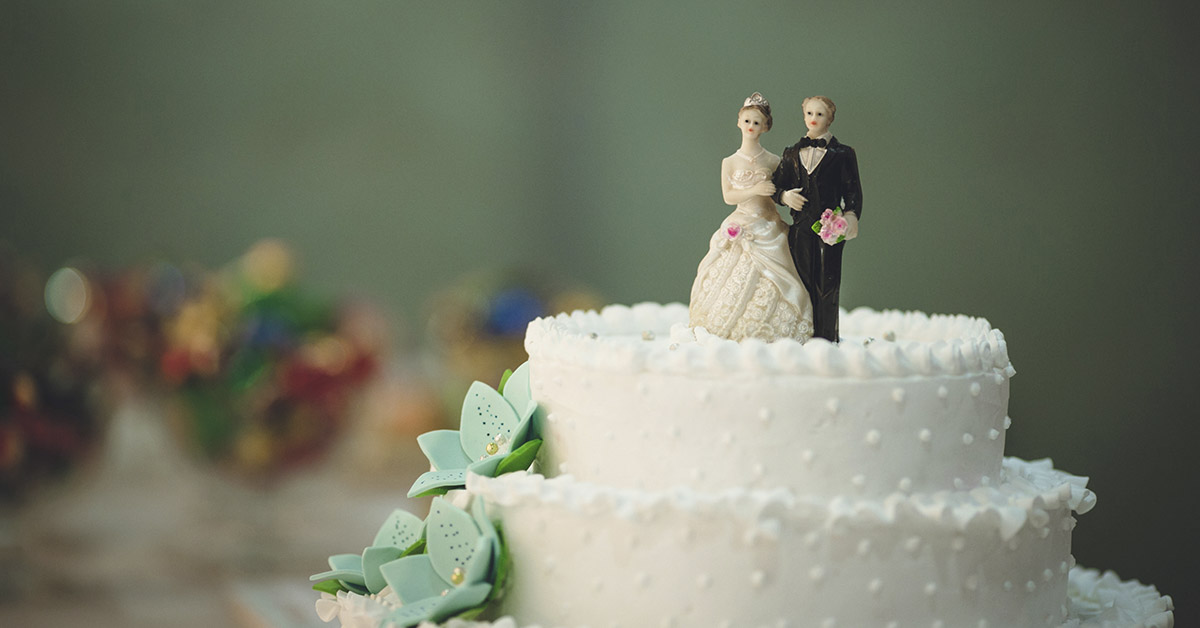 Wedding cake with bride and groom decoration featured on top