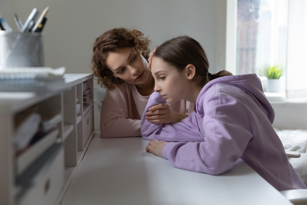 Loving Caucasian mom comfort support unhappy teenage 13s daughter feeling lonely at home. Caring mother cheer sad teen girl child suffering from school discrimination bullying. Loner concept.