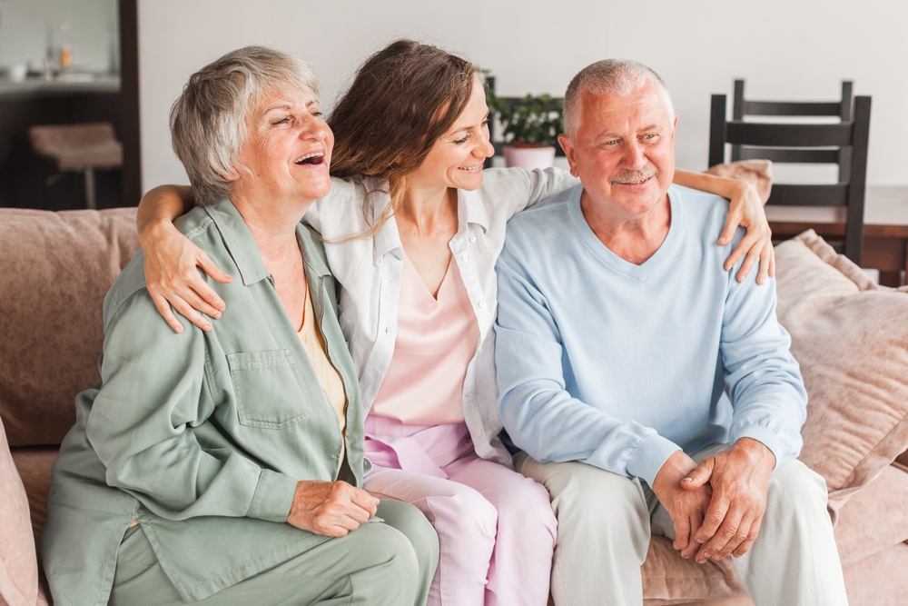 Family portrait happy beautiful faces, adult daughter embracing 60s father middle-aged mother closest relatives people, good relations concept. Dad, mom and adult daughter at home