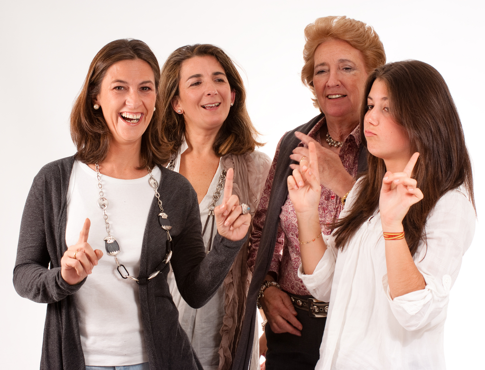 Isolated image of four women of different generations laughing together