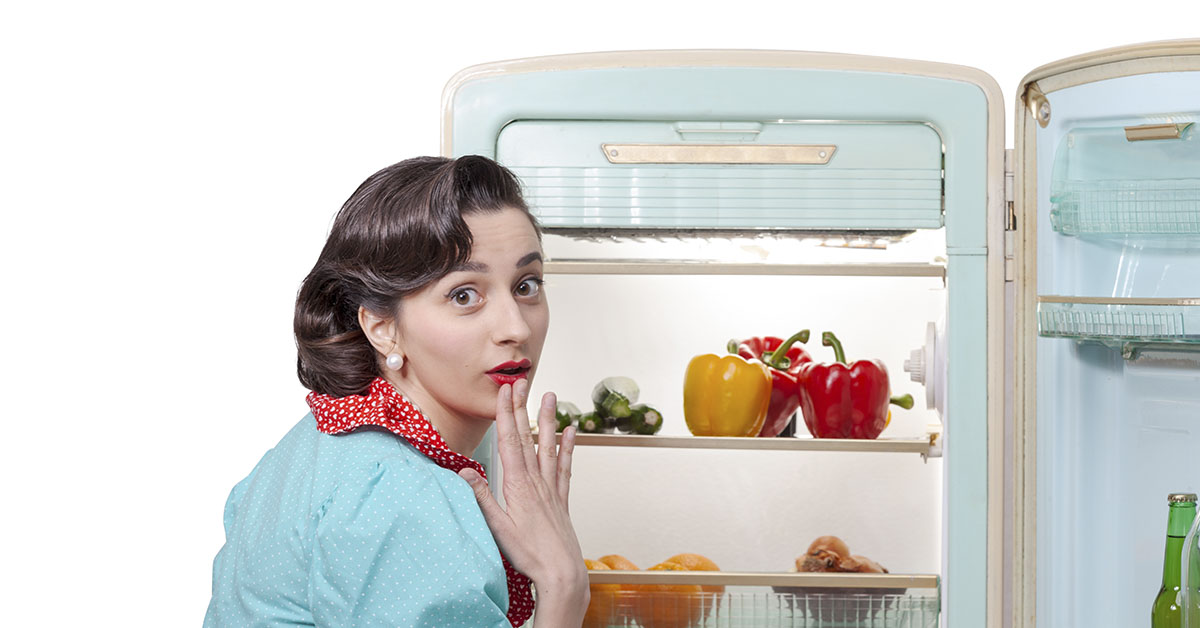 woman looking opening vintage fridge