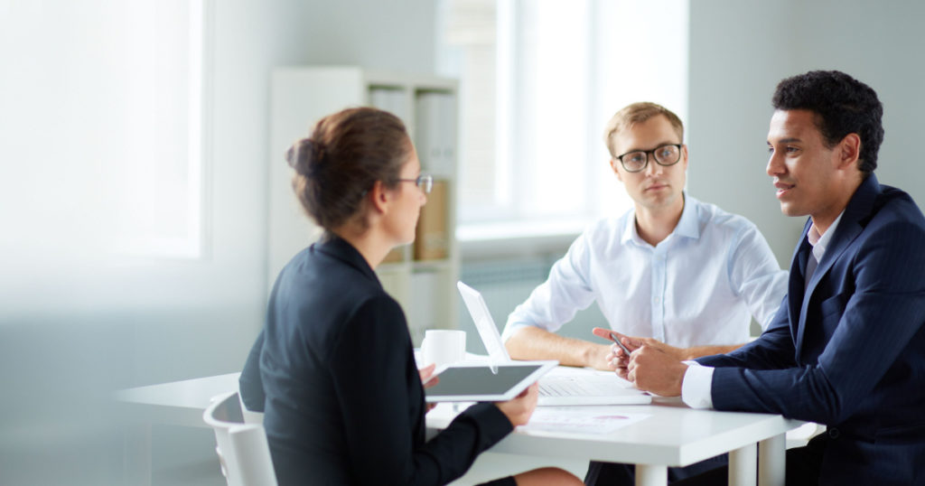 Portrait of smart business partners communicating at meeting