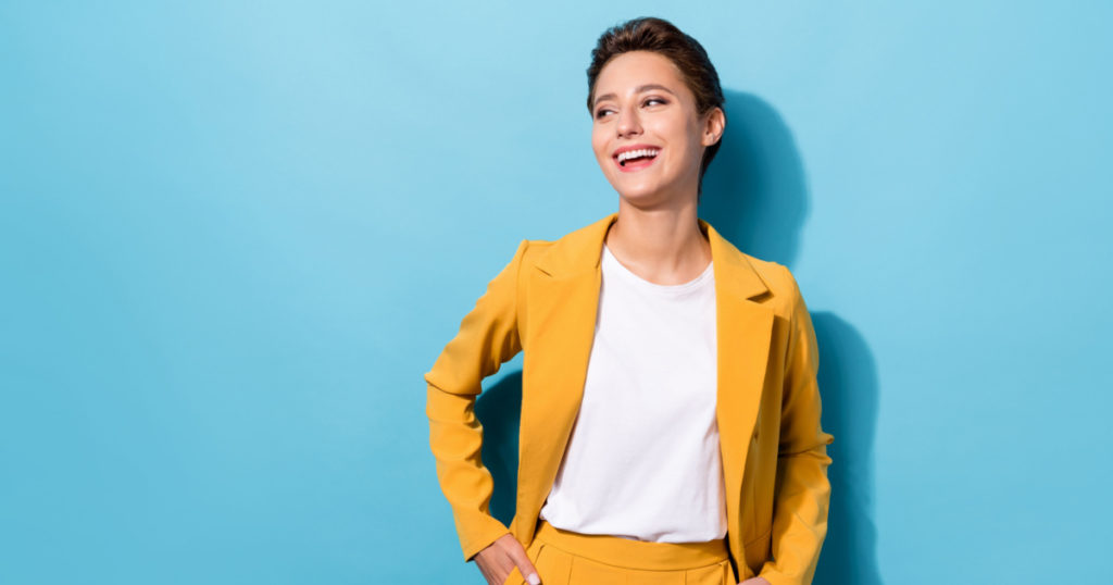Photo portrait business woman wearing yellow blazer laughing looking copyspace isolated pastel blue color background