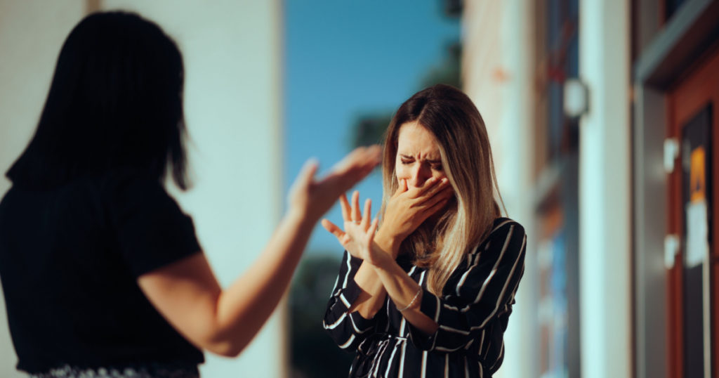 Woman Crying Fighting with Her Best Friend Outdoors. Unhappy emotional girl disagreeing with her sister