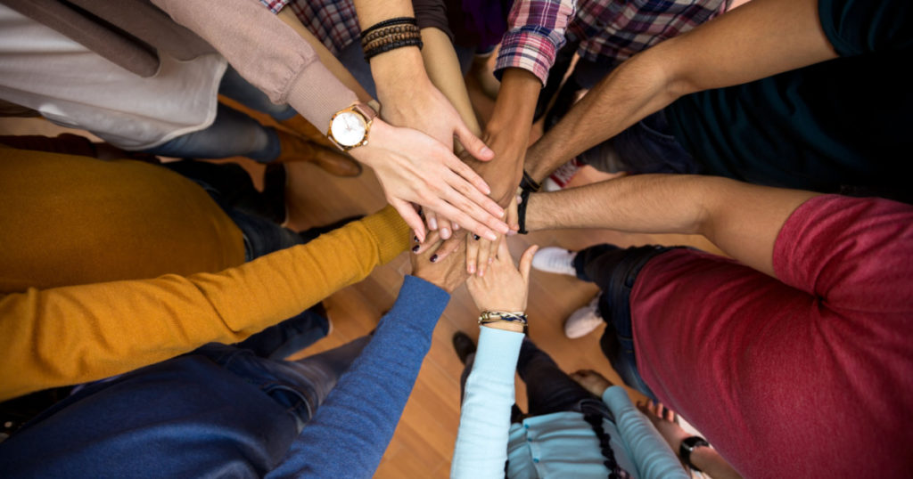 Unidad y concordia en equipo multiétnico, todas las manos juntas