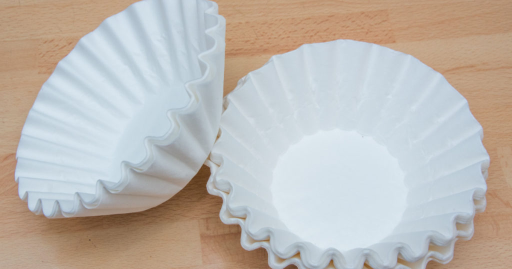 Coffee filters made from paper isolated on a wooden background