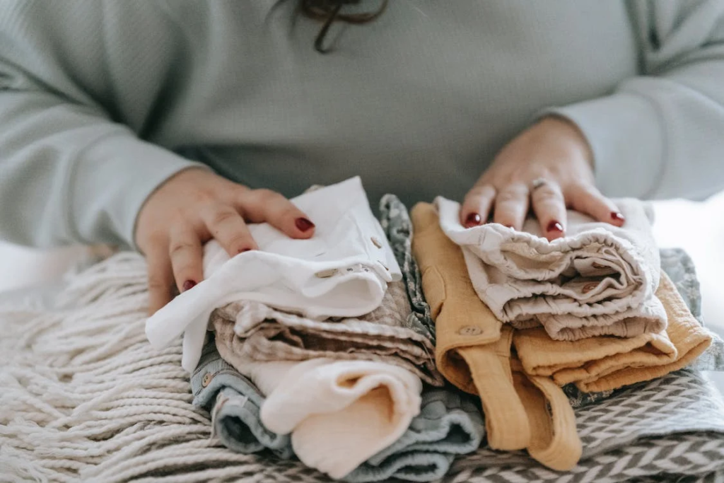 clean house - Unrecognizable woman with folded clean baby clothes
