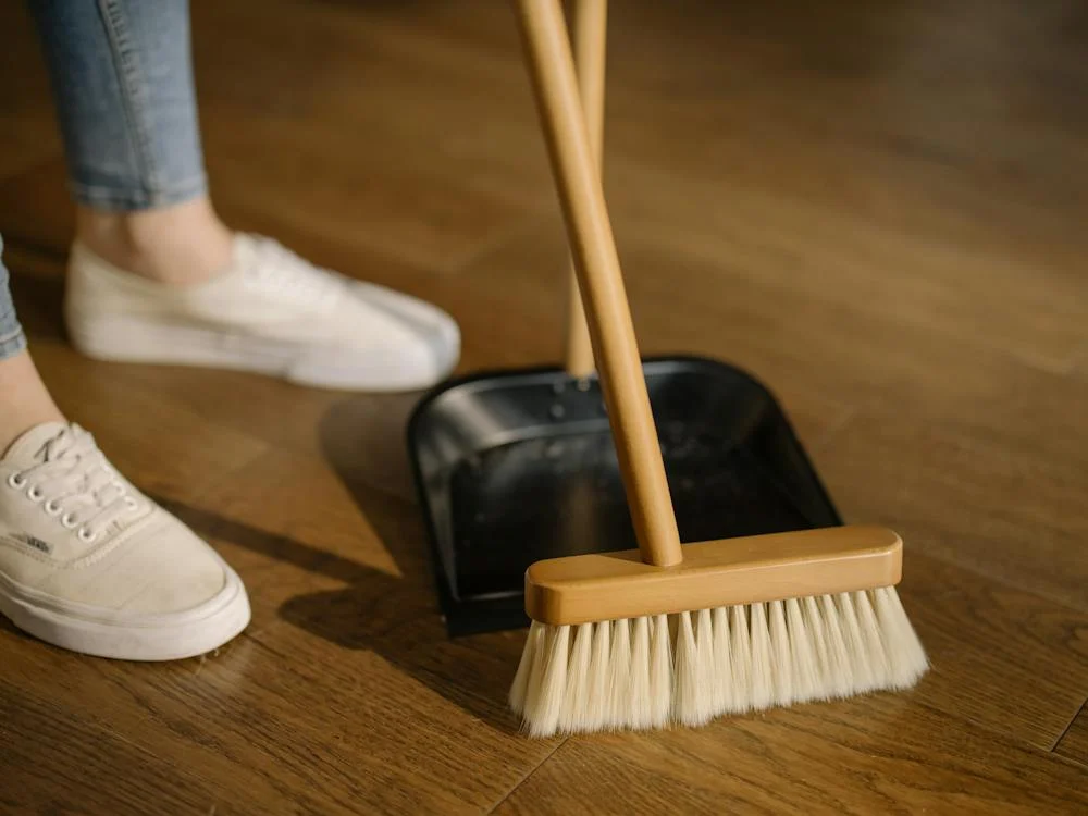 clean house - Person Wearing jeans and White Shoes Standing Beside Brown Broom
