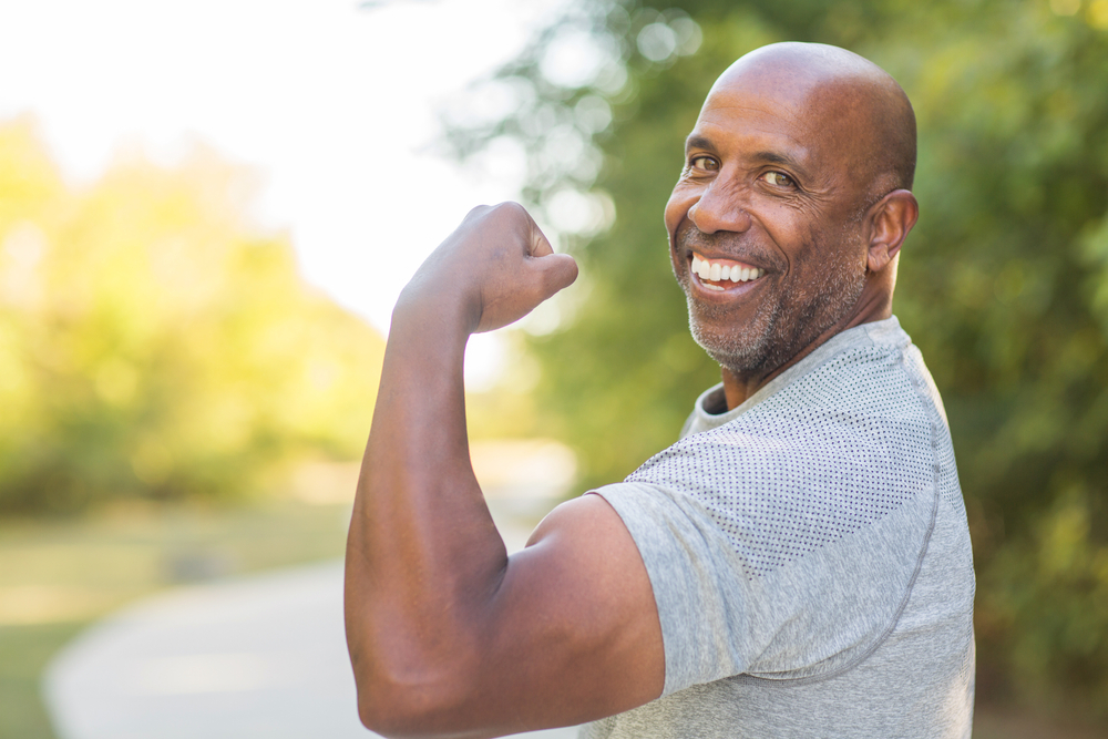 Healthy African American man flexing and doing a bicep curl