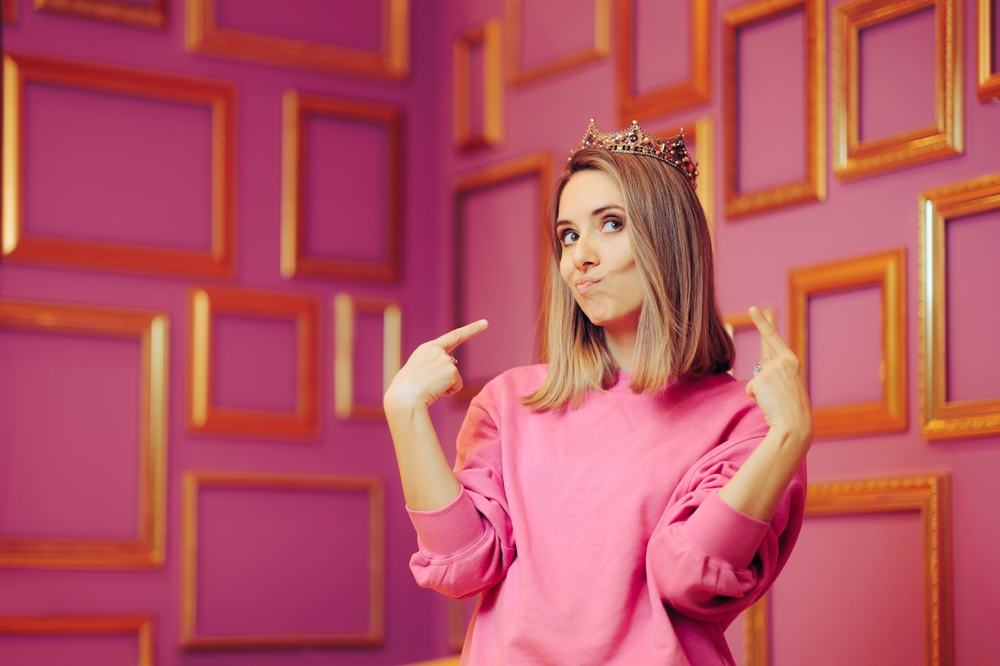 Vain Queen Wearing a Crown Pointing to Herself. Attention seeker diva behaving princess girl feeling self-important and overconfident