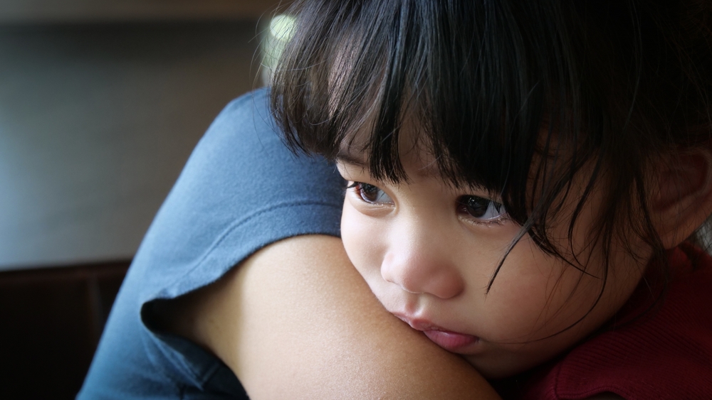 Sad Little Girl is crying in the arms of his mother. Mother and baby with tears in their eyes emotionally embrace. A loving mother hugs and comforts her little daughter. Mom calms child. Family love.