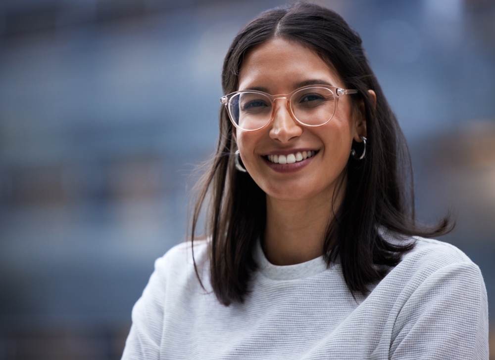 Woman, portrait and smile with glasses in closeup, entrepreneur and vision for career. Designer, happiness and worker with confidence on break in city for relax in town with professional in New York.