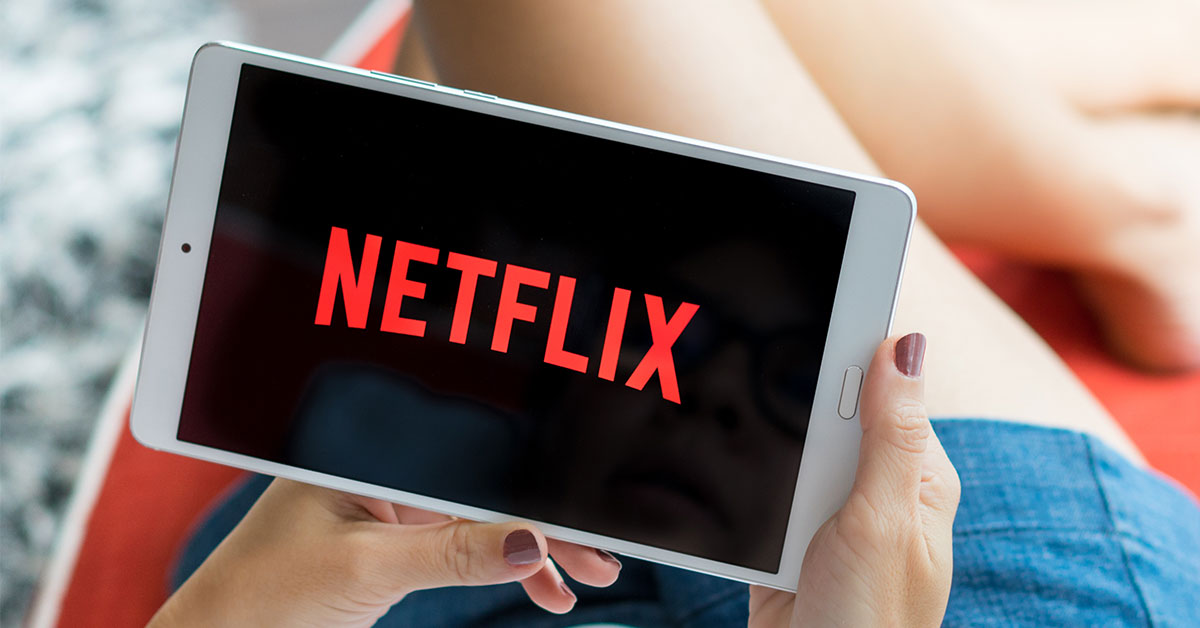 Person holding tablet displaying Netflix