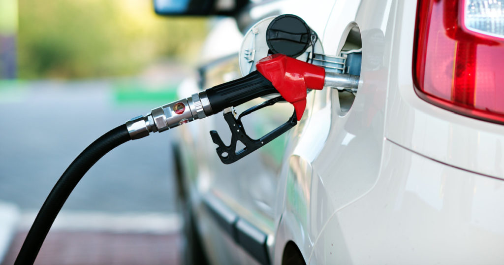 To fill the machine with fuel. Mashunya fill with gasoline at a gas station. Gas station pump. Man filling gasoline fuel in car holding nozzle. Close up.