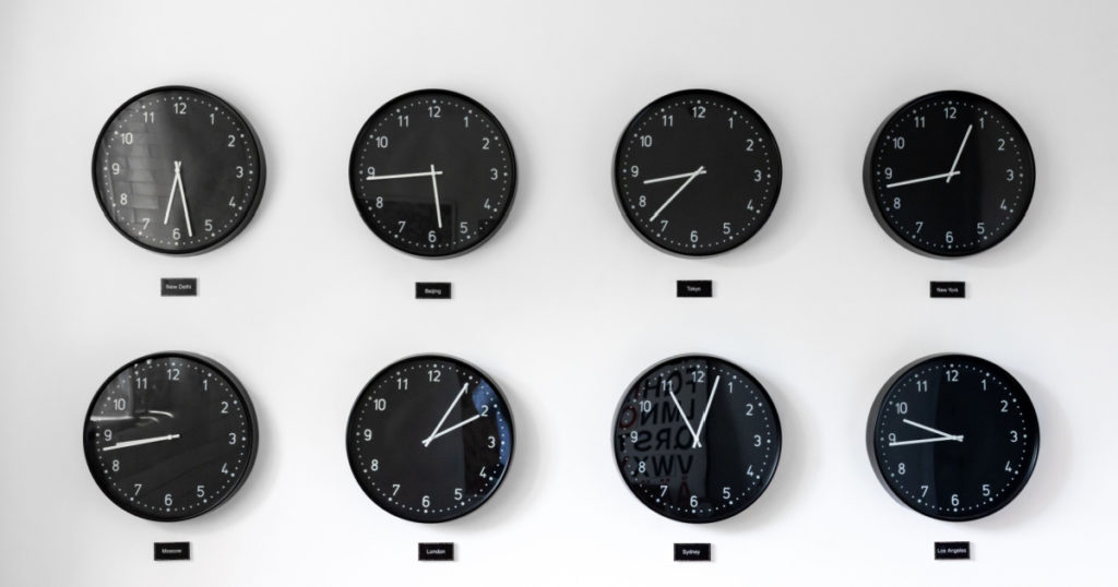 Different times al around the world including Great Britain, Russia and Honk Kong. Eight clocks on wall showing world time zones.