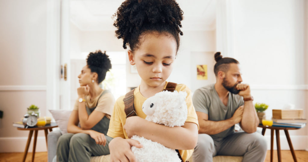 Divorce, fight and sad boy child with teddy bear in a living room for stress, support and comfort at home. Family, crisis and kid with anxiety for toxic parents, argue or dispute, depression or fear