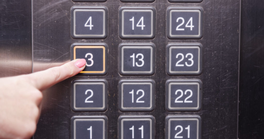 Third (3rd) floor elevator button is pushed by a female finger