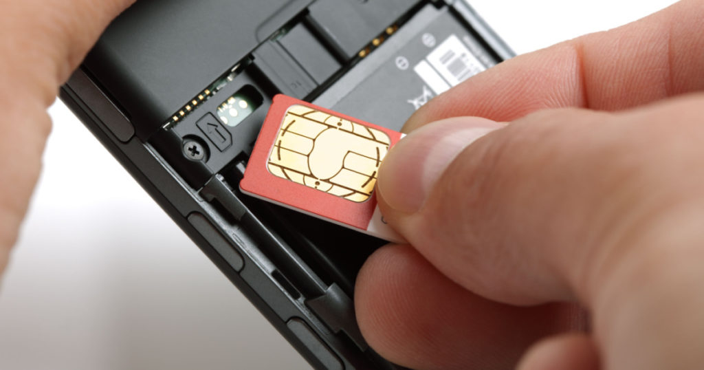 Inserting a sim card into the back of a mobile phone