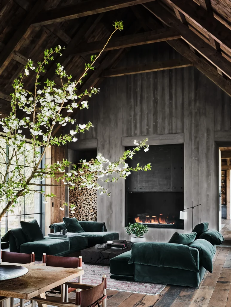 Green furniture in front of a lit fireplace.