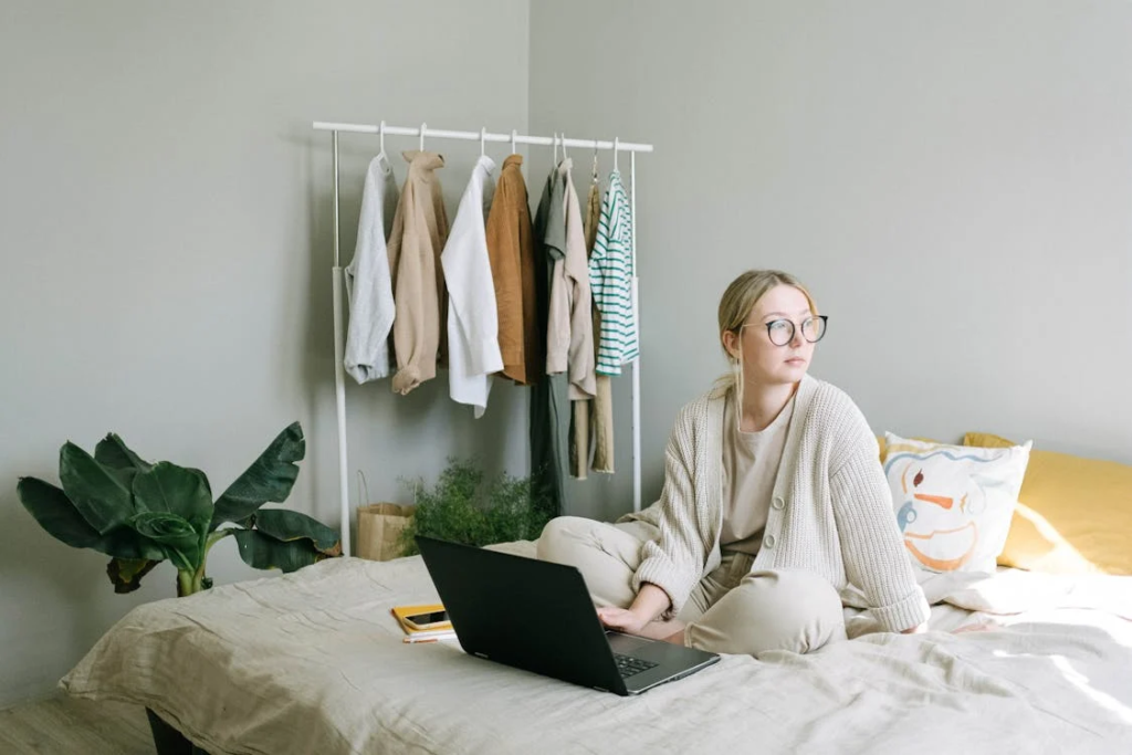 stay-at-home jobs - A Woman in Beige Sweater Sitting on the Bed
