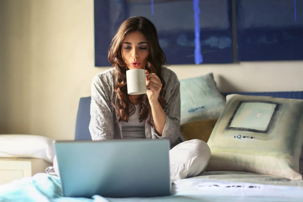 stay-at-home jobs - Woman in Grey Jacket Sits on Bed Uses Grey Laptop
