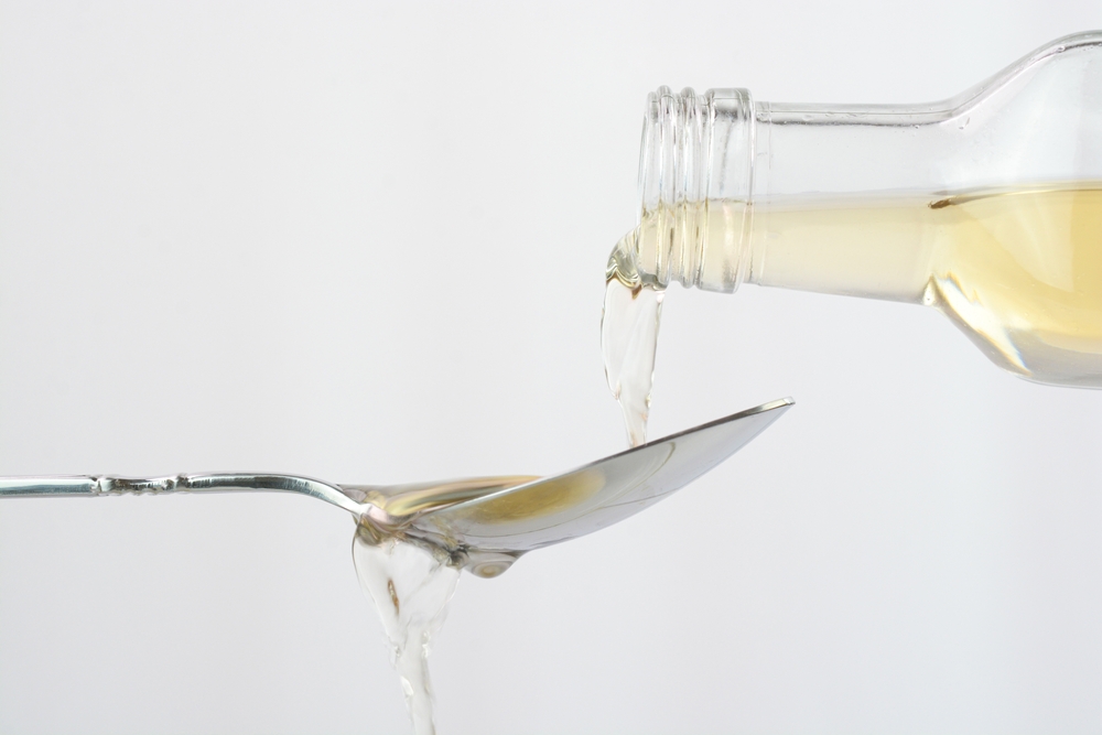 Pouring apple cider vinegar in a spoon