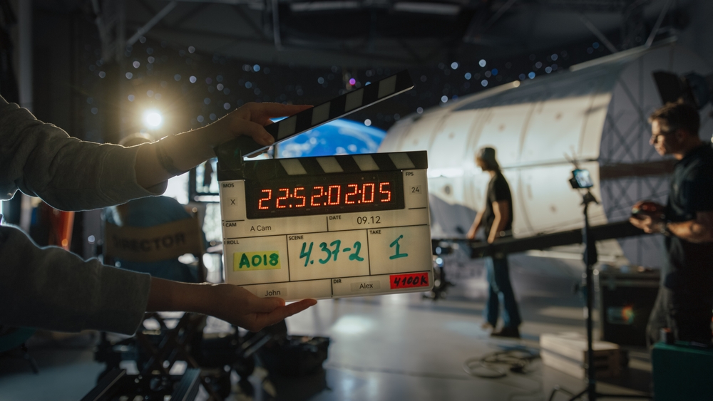 Director Filming Ad Shoot With Astronaut Fixing Satellite. Actor Floats on Rope Against Digital Earth Backdrop. Behind-the-scenes of Commercial Production.